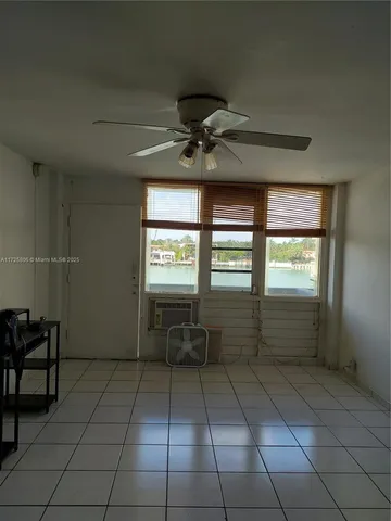 a room with lots of white furniture and a window