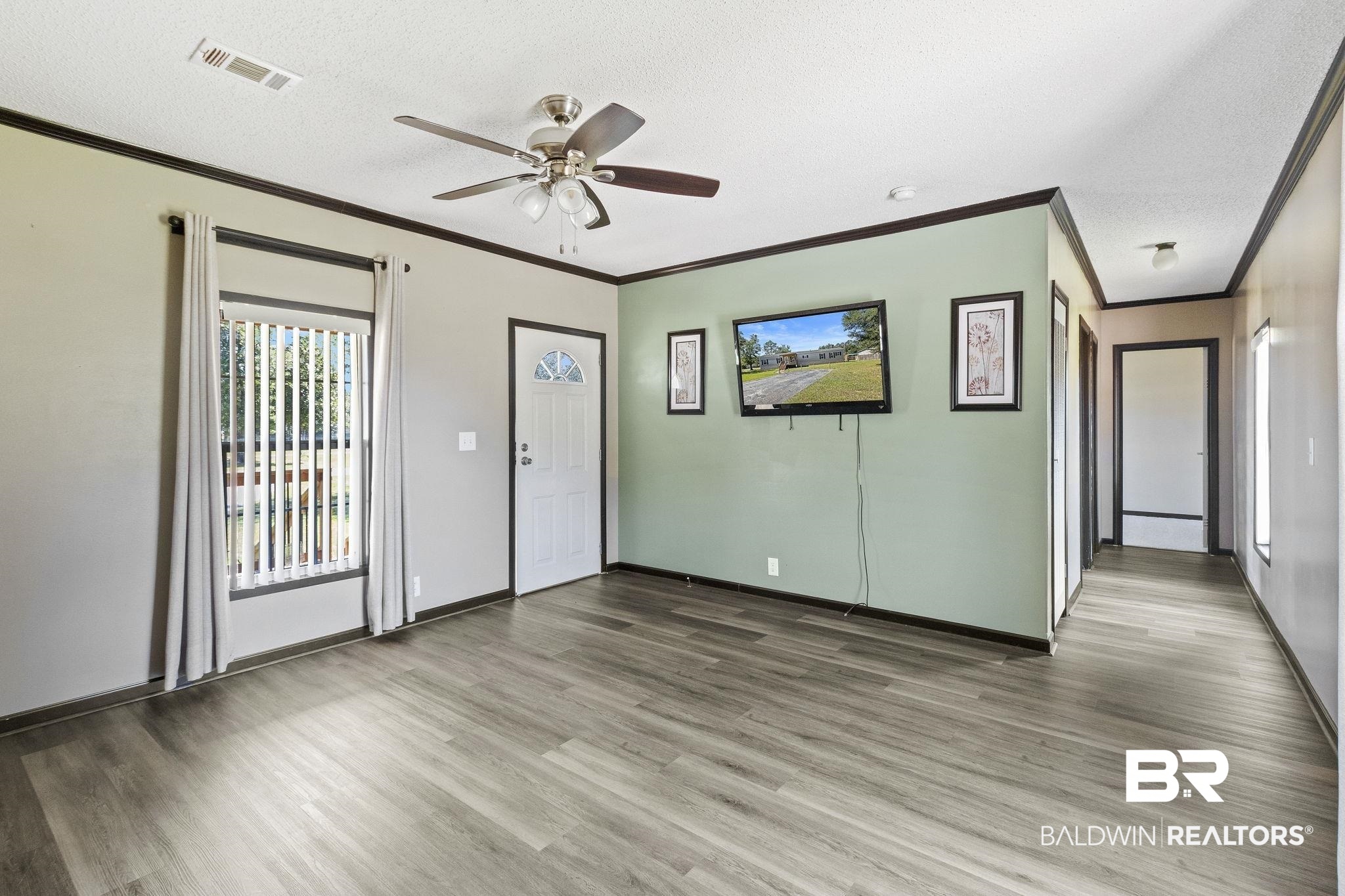 6870 Cecilia Court Theodore, AL 36582 - Photo 15 of 83 Unfurnished room featuring ceiling fan, ornamental molding, a textured ceiling, and hardwood / wood-style floors