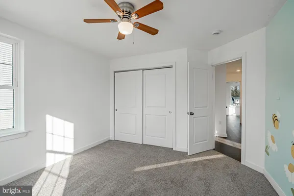 a view of a room with a ceiling fan and a window
