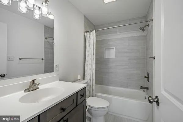 a view of a livingroom with wooden floor and a ceiling fan