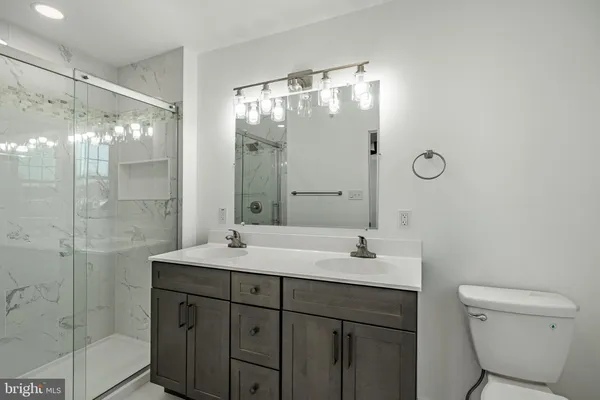 a bathroom with a shower sink vanity and mirror