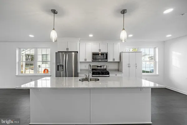 a kitchen with stainless steel appliances a refrigerator sink and microwave