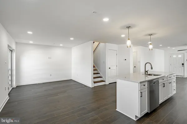 a view of a kitchen with a sink and dishwasher with wooden floor