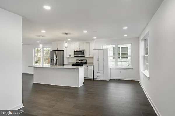 a kitchen with stainless steel appliances refrigerator cabinets and wooden floor