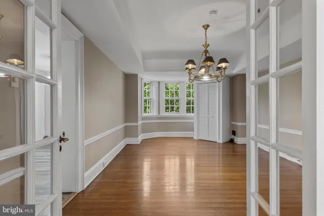 a view of a hallway with windows and chandelier
