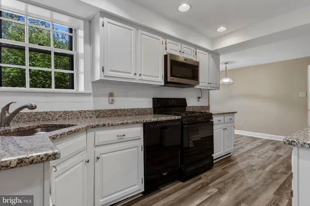 a kitchen with stainless steel appliances granite countertop a stove and a microwave