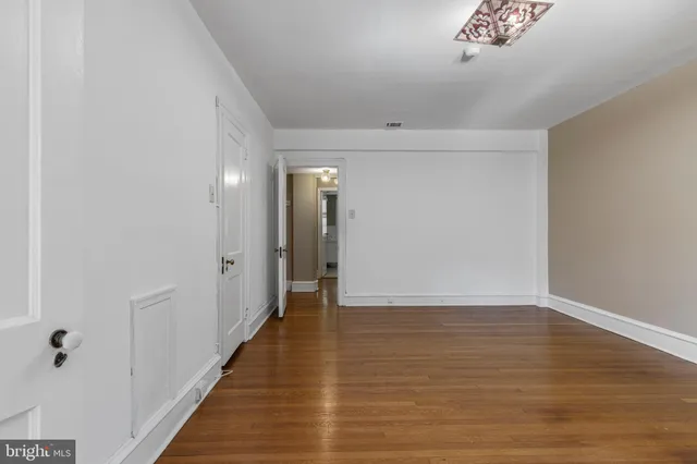 a view of an empty room with wooden floor