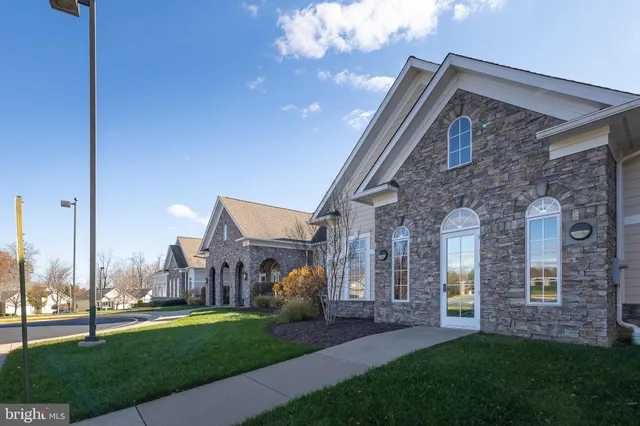 a view of a big house with a big yard and large trees