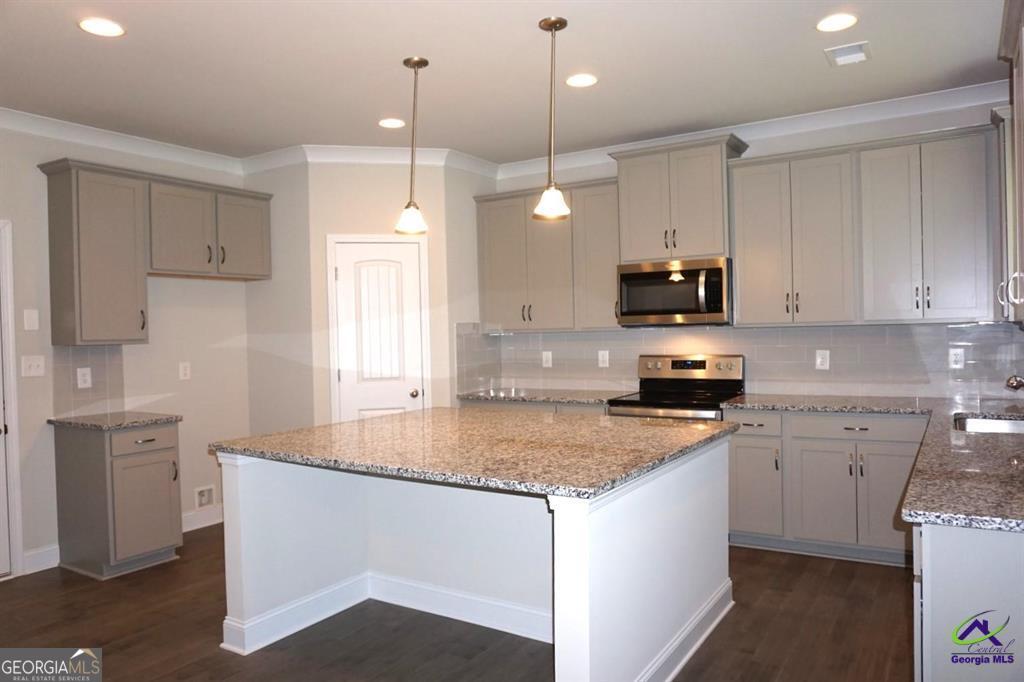 121 Bluecoat Trail Byron, GA 31008 - Photo 29 of 45 a kitchen with stainless steel appliances granite countertop a sink a stove and a granite counter tops
