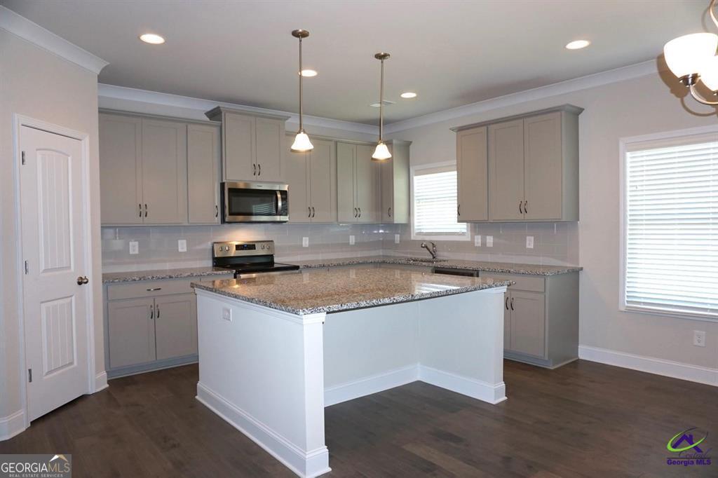 121 Bluecoat Trail Byron, GA 31008 - Photo 30 of 45 a kitchen with granite countertop a sink cabinets and stainless steel appliances