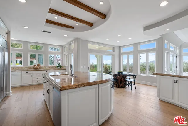 a kitchen with stainless steel appliances granite countertop a kitchen island a stove a table and chairs