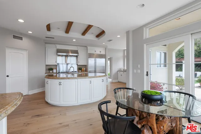 a kitchen with stainless steel appliances granite countertop a sink a stove and a refrigerator