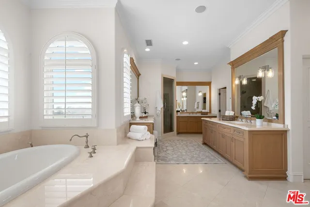 a large bathroom with a large tub sink and glass door