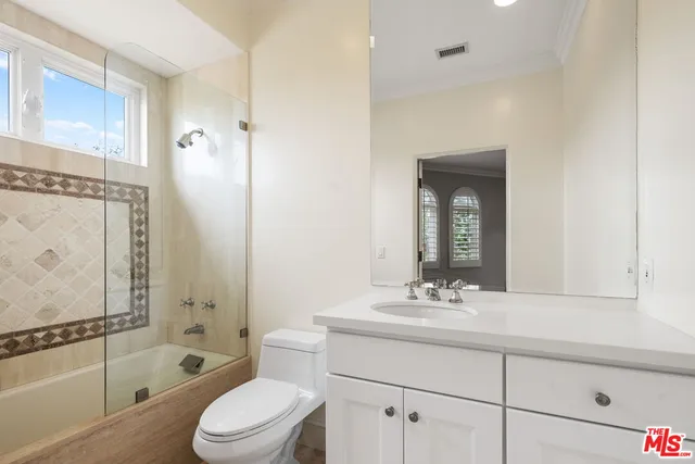 a front view of a house with a garden and lake view