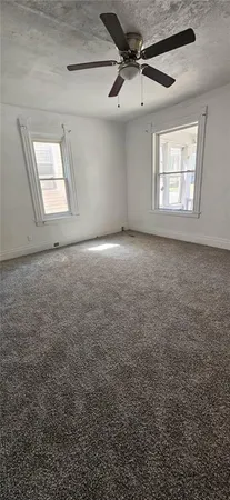 a view of a livingroom with a ceiling fan and window