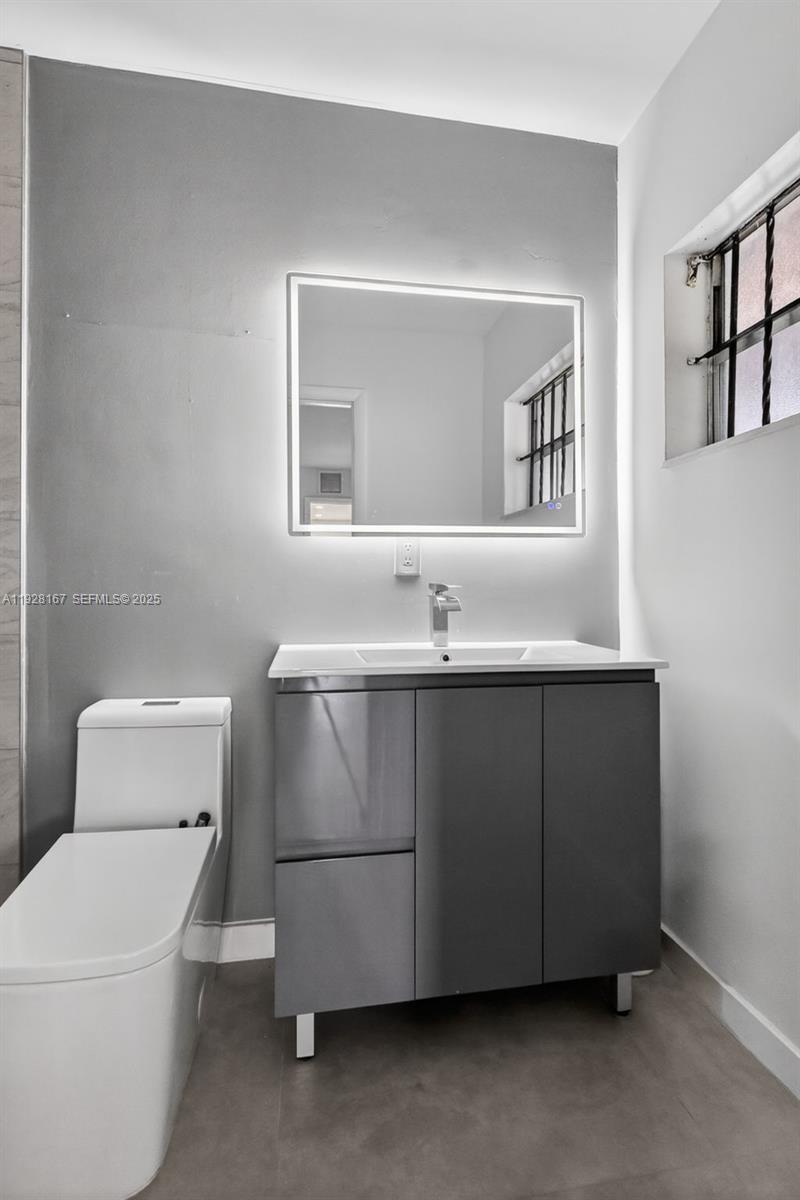 708 Southwest 10th Street, Unit 1 Dania Beach, FL 33004 - Photo 11 of 23 a bathroom with a sink toilet and mirror