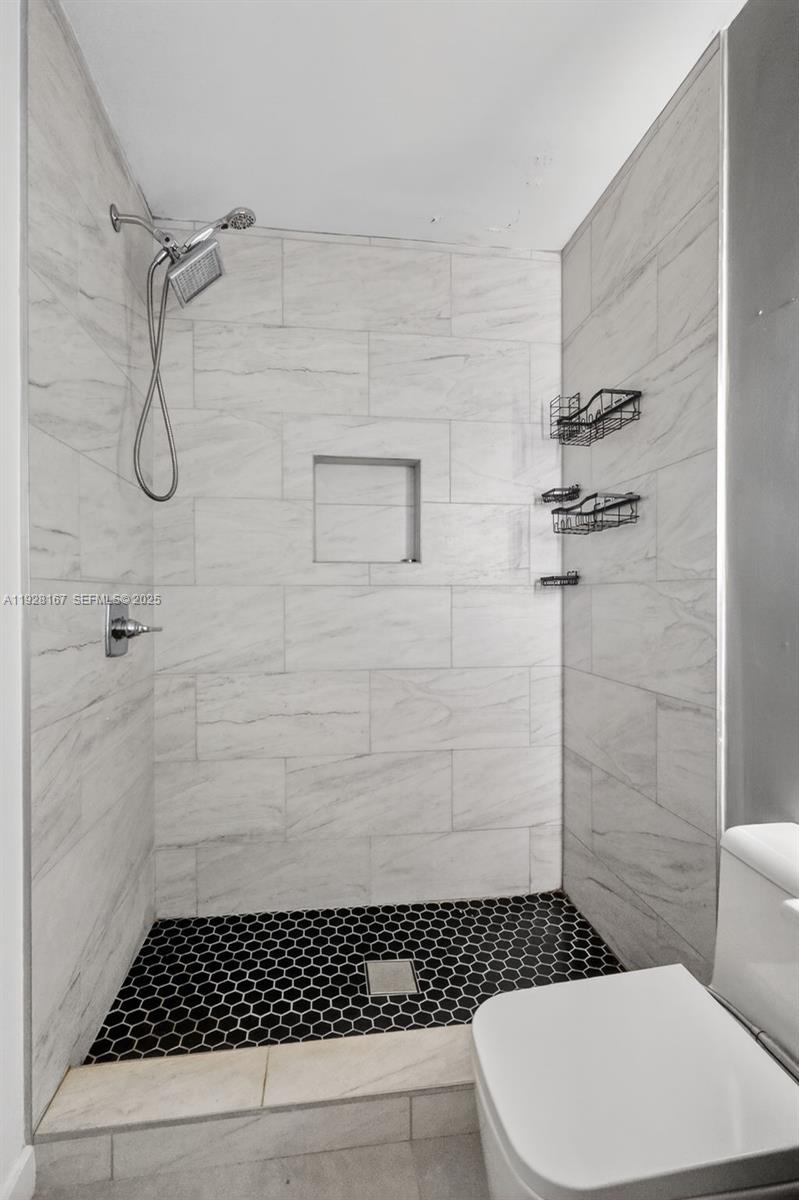 708 Southwest 10th Street, Unit 1 Dania Beach, FL 33004 - Photo 12 of 23 a bathroom with a toilet a sink and shower