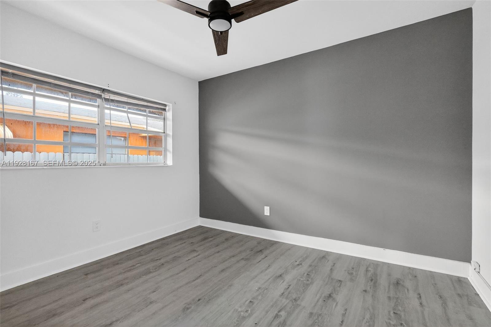 708 Southwest 10th Street, Unit 1 Dania Beach, FL 33004 - Photo 13 of 23 wooden floor in an empty room with a window