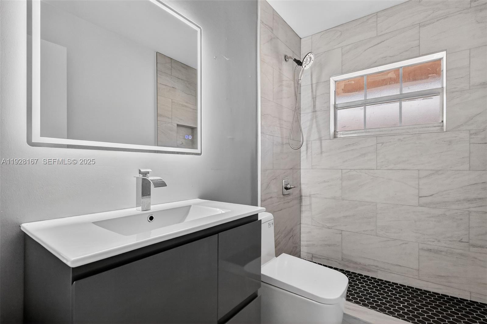 708 Southwest 10th Street, Unit 1 Dania Beach, FL 33004 - Photo 15 of 23 a bathroom with a sink a toilet and shower