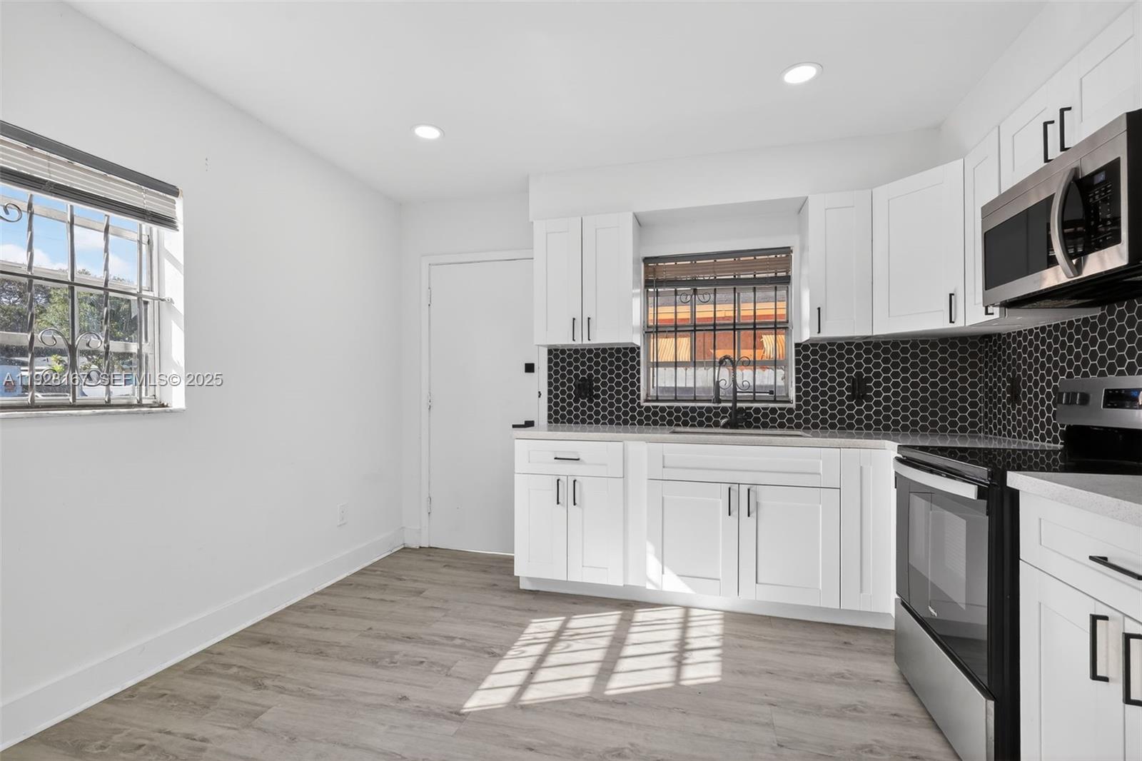 708 Southwest 10th Street, Unit 1 Dania Beach, FL 33004 - Photo 2 of 23 a kitchen with stainless steel appliances granite countertop a stove a sink and a microwave