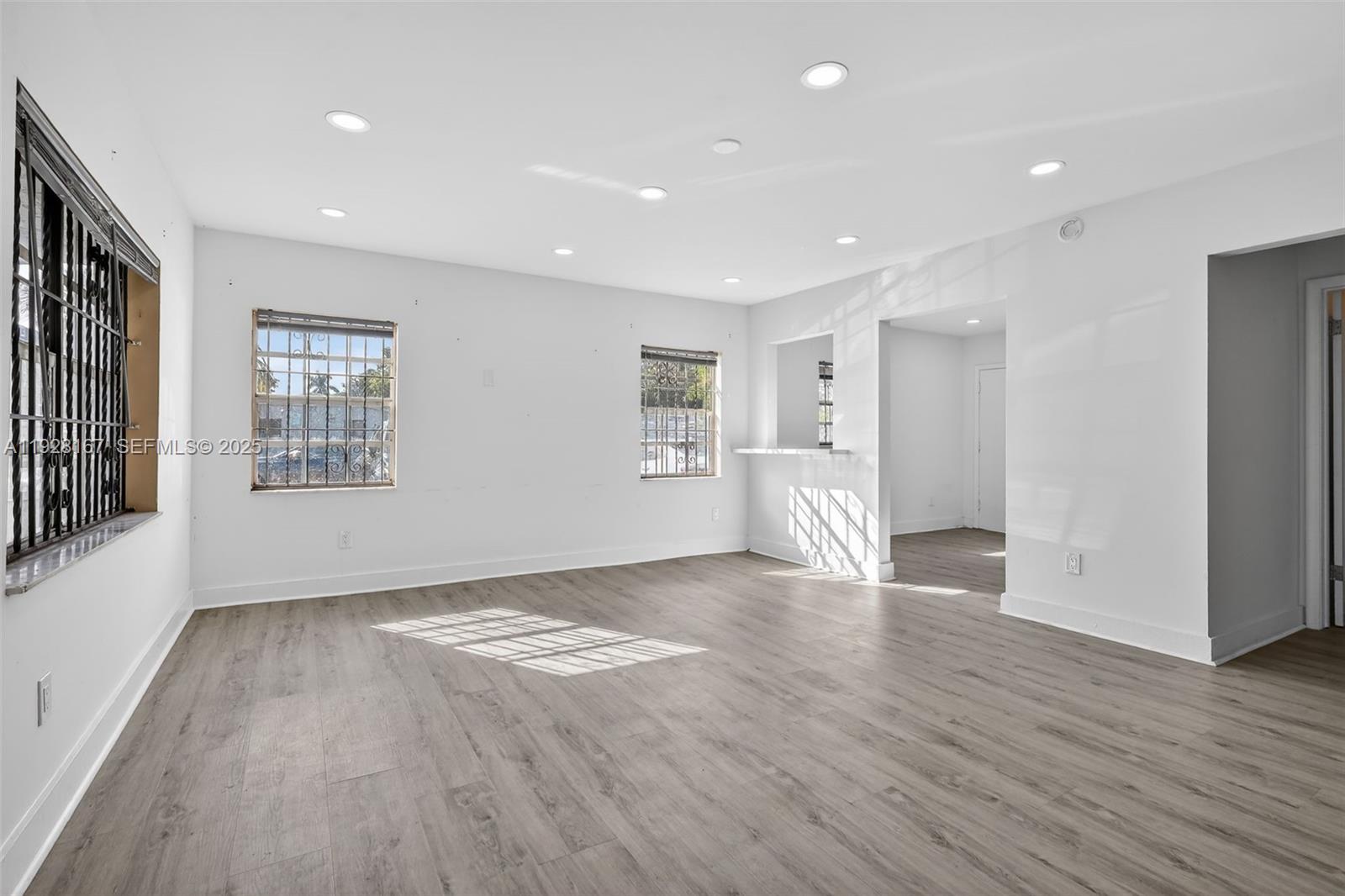 708 Southwest 10th Street, Unit 1 Dania Beach, FL 33004 - Photo 5 of 23 a view of an empty room with wooden floor and a window