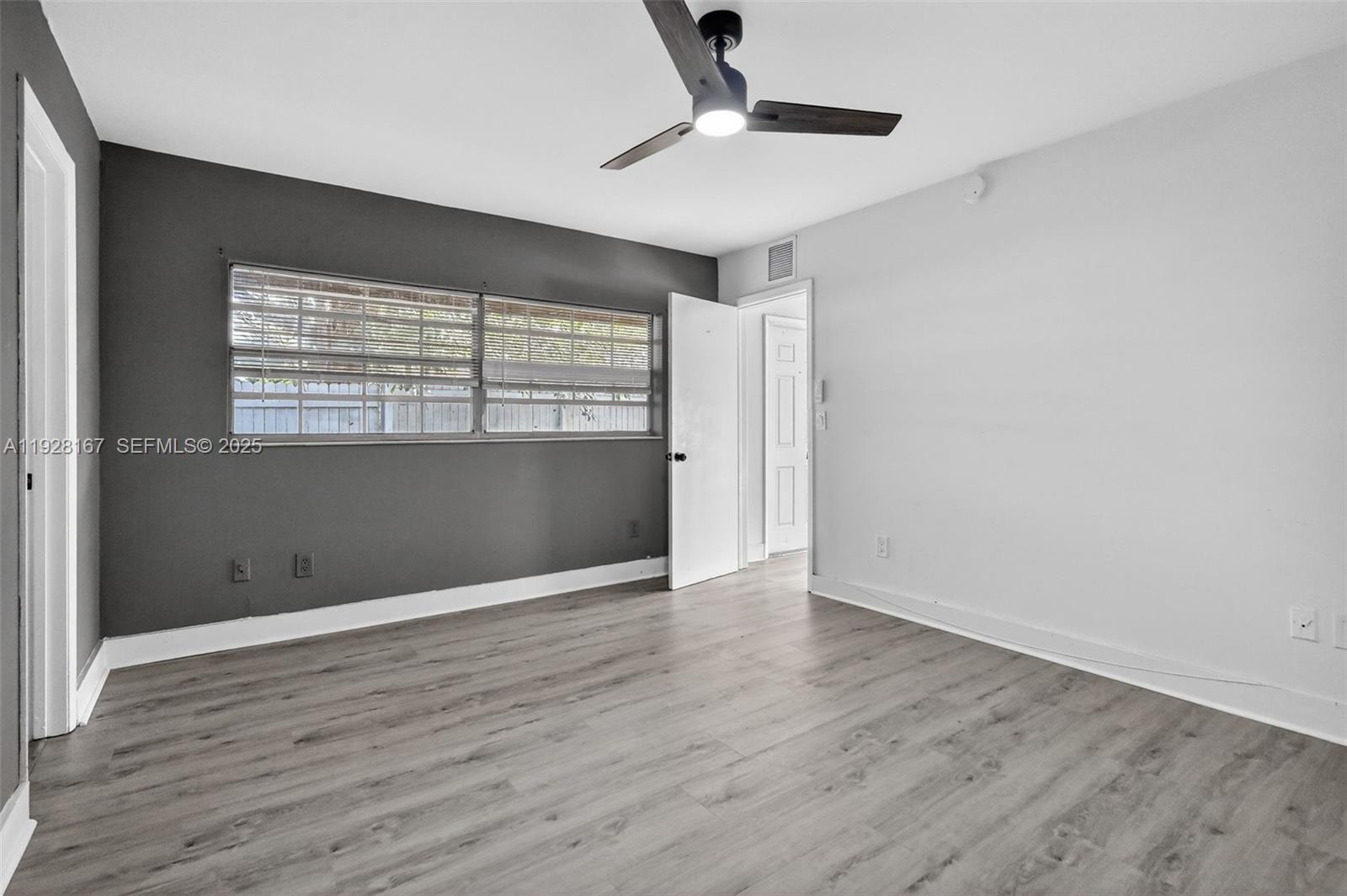 708 Southwest 10th Street, Unit 1 Dania Beach, FL 33004 - Photo 10 of 23 wooden floor in an empty room with a window