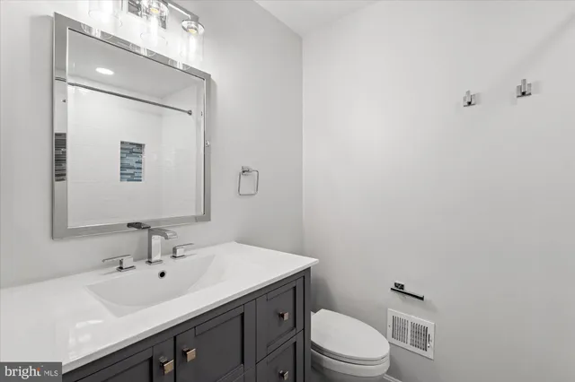 a bathroom with a sink toilet and mirror