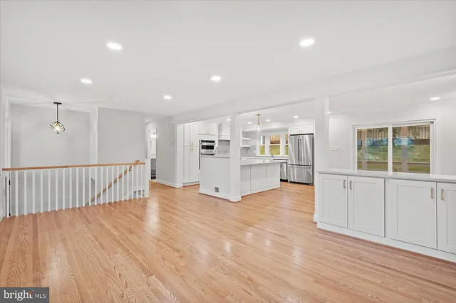 a view of an empty room with wooden floor and windows
