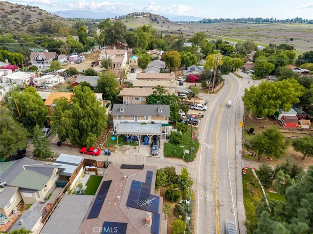 an aerial view of a city with lots of residential buildings ocean and mountain view in back
