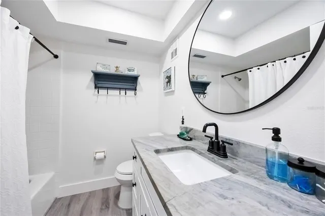 a bathroom with a granite countertop sink mirror and toilet