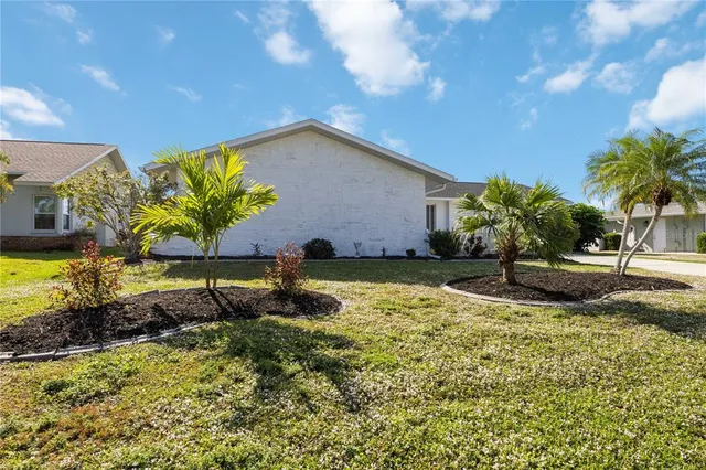 an aerial view of residential houses with outdoor space and trees