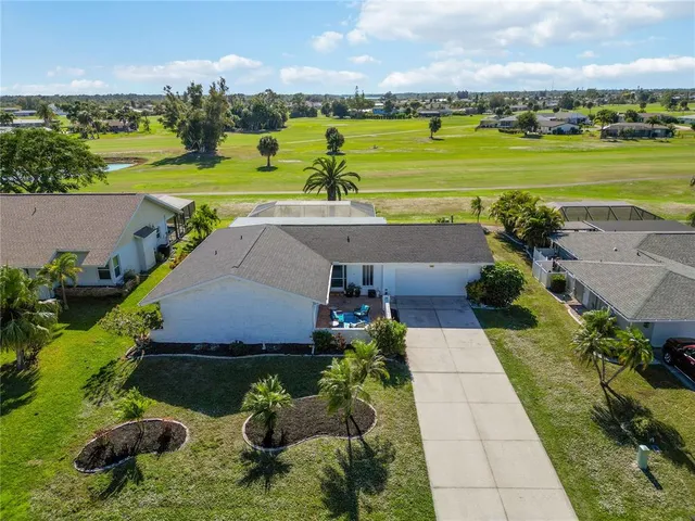 an aerial view of a city with lots of residential buildings ocean and mountain view in back