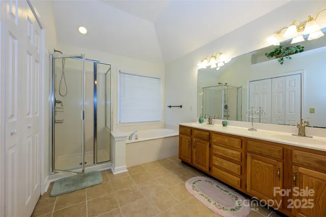 a bathroom with a double vanity sink mirror and shower