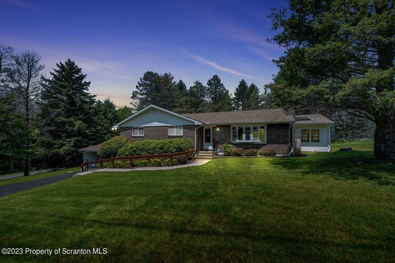 a front view of a house with yard and green space