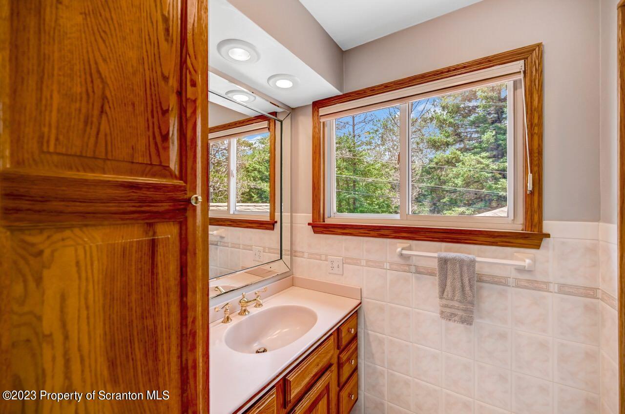 3 T-338 Moscow, PA 18444 - Photo 29 of 62 a bathroom with a granite countertop sink and a window