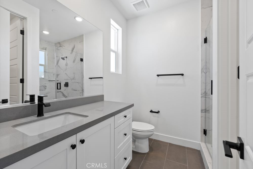 29818 Old Ranch Circle Castaic, CA 91384 - Photo 31 of 41 a bathroom with a granite countertop sink a toilet and shower