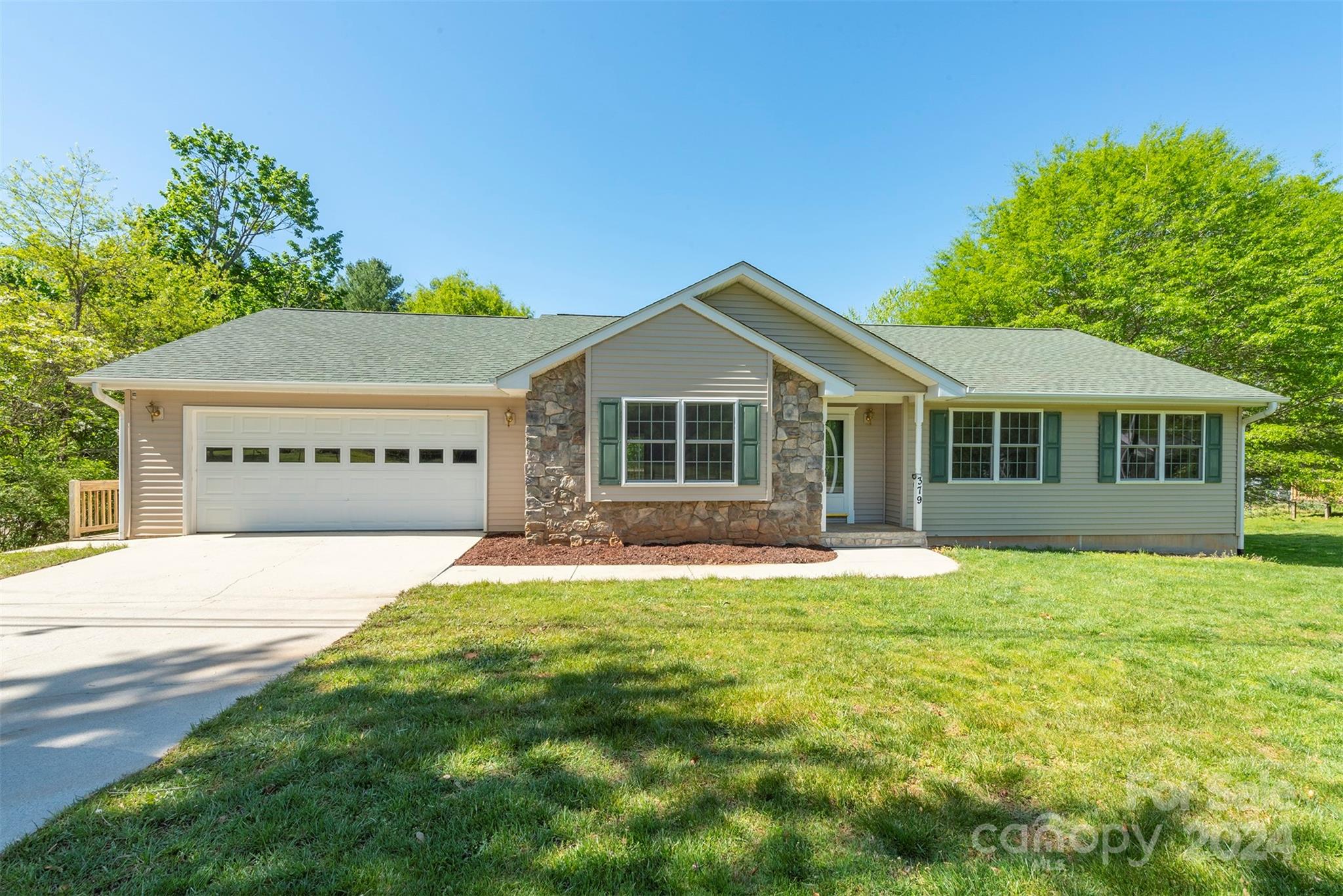 379 Buckeye Cove Road Swannanoa, NC 28778 - Photo 4 of 31 a front view of a house with a garden