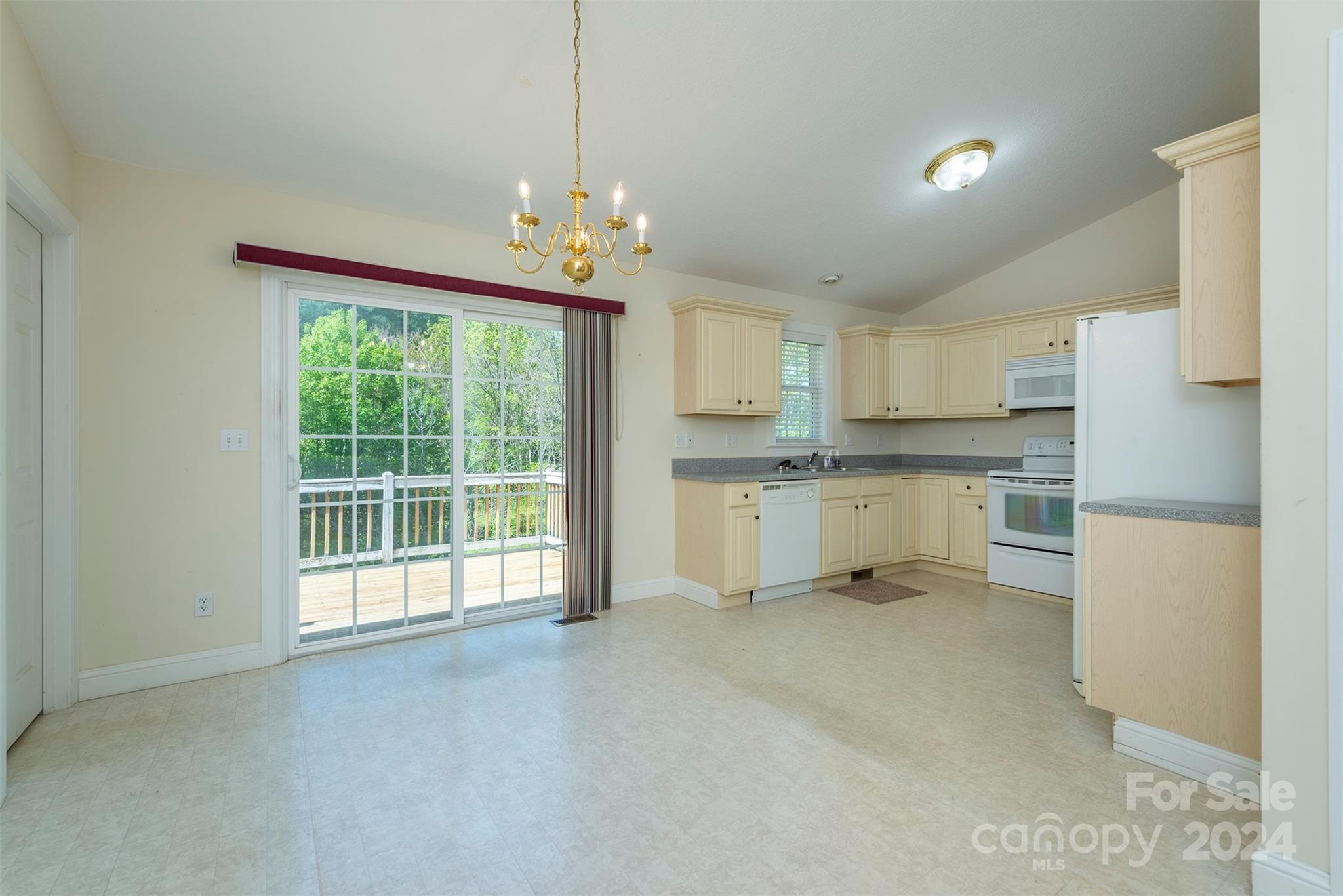 379 Buckeye Cove Road Swannanoa, NC 28778 - Photo 5 of 31 a view of a kitchen with a sink a refrigerator and white cabinets