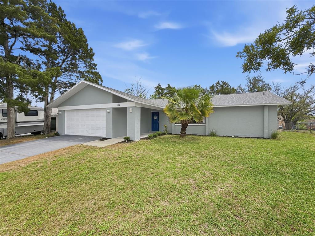 5384 Baldock Avenue Spring Hill, FL 34608 - Photo 1 of 51 a front view of house with yard and trees in the background