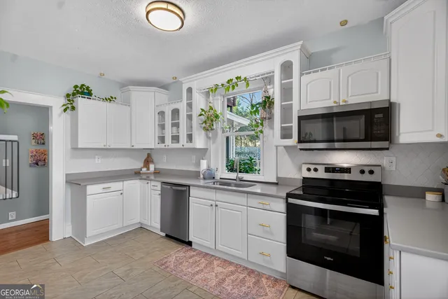 a view of a kitchen with refrigerator and wooden floor