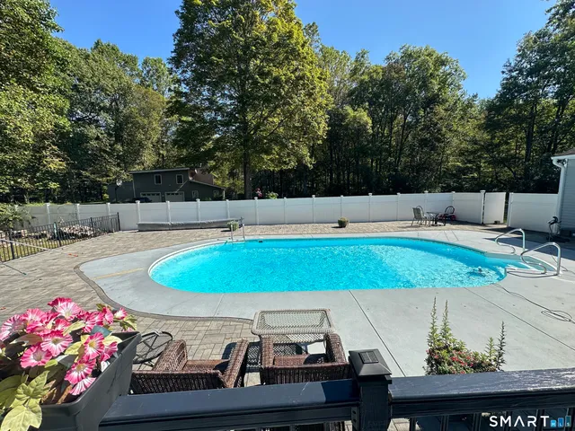a living room with furniture a floor to ceiling window and a flat screen tv