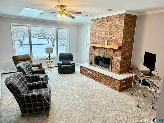 a living room with furniture a flat screen tv and a fireplace