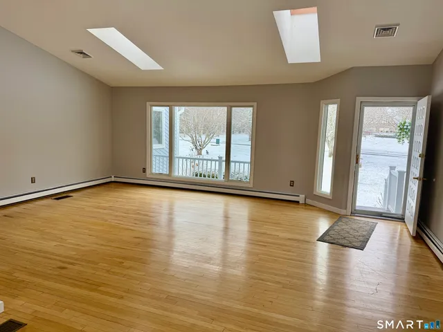a view of empty room with wooden floor and fireplace
