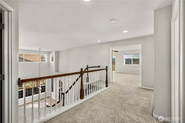 a view of a hallway with wooden floor and windows