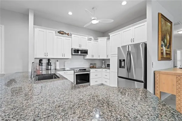 a kitchen with stainless steel appliances white cabinets and a refrigerator