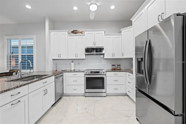 a kitchen with white cabinets and sink
