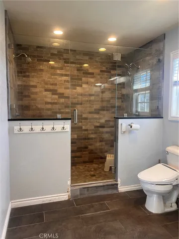 a bathroom with a toilet and a shower