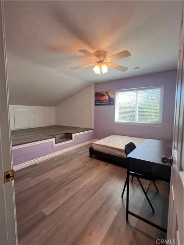 a room with chandelier fan and windows