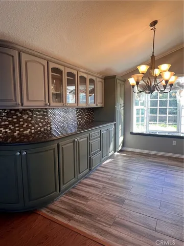 a kitchen with stainless steel appliances granite countertop a stove a sink dishwasher a microwave oven and a dining table with wooden floor