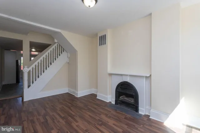 a view of empty room with wooden floor and fireplace